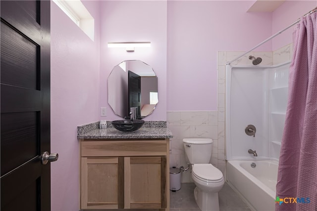 full bathroom featuring tile patterned flooring, shower / bath combination with curtain, vanity, toilet, and tile walls