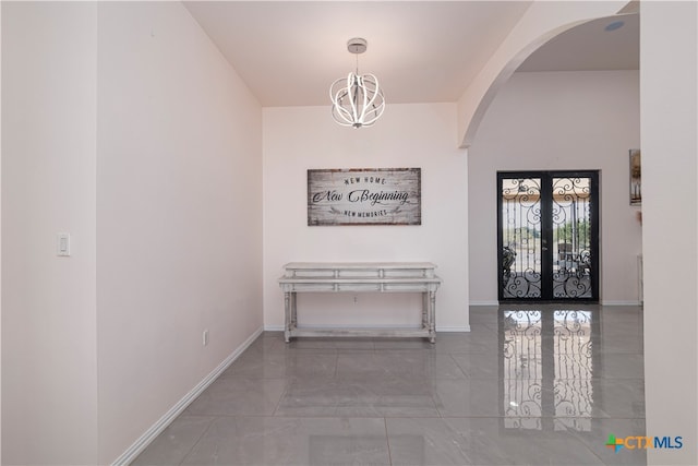 hall with french doors and a notable chandelier