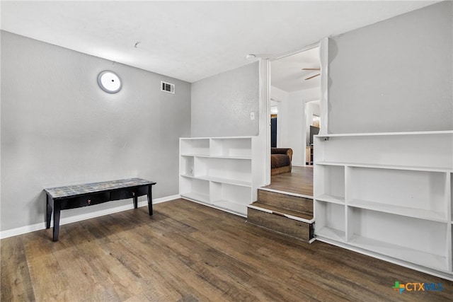 interior space featuring visible vents, a ceiling fan, baseboards, and wood finished floors