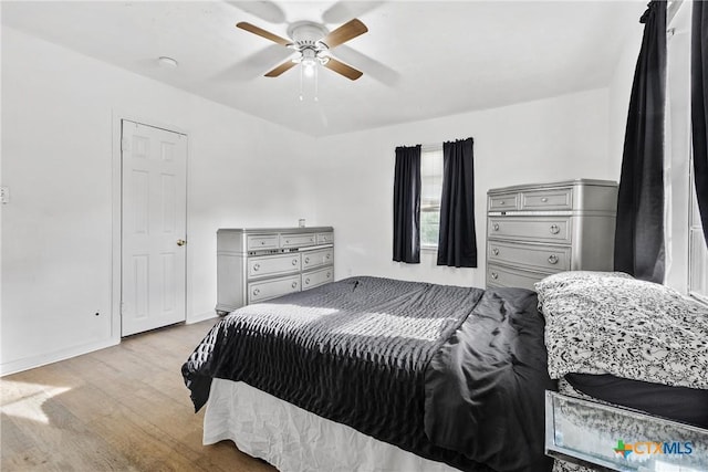 bedroom featuring baseboards, ceiling fan, and wood finished floors