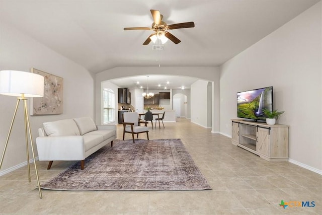 living room with ceiling fan with notable chandelier