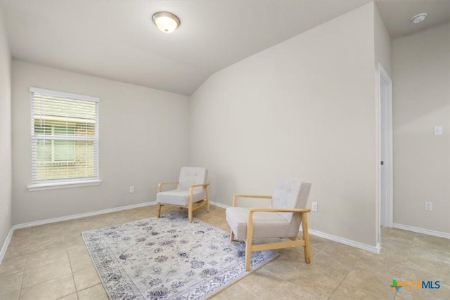 living area with light tile patterned flooring and vaulted ceiling