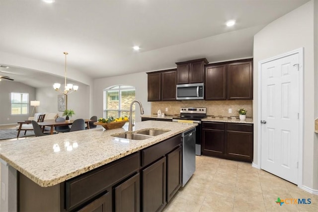 kitchen with stainless steel appliances, sink, a center island with sink, a notable chandelier, and hanging light fixtures