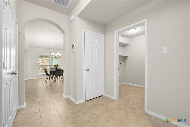 hall featuring a notable chandelier and light tile patterned flooring