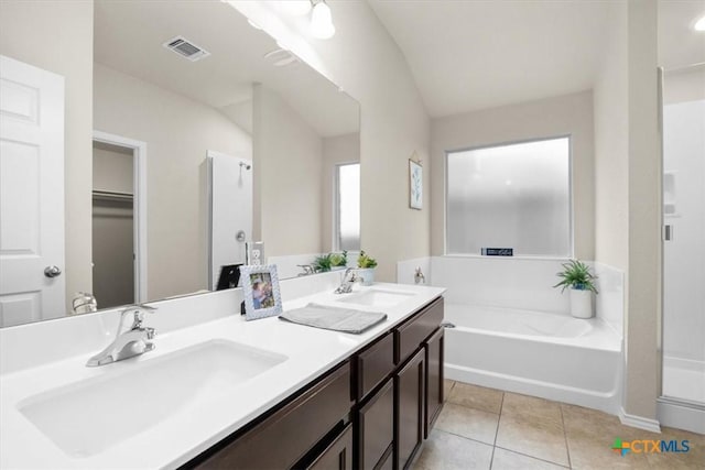 bathroom with vanity, a tub to relax in, and tile patterned floors