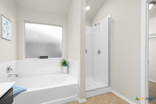 bathroom with vanity and shower with separate bathtub