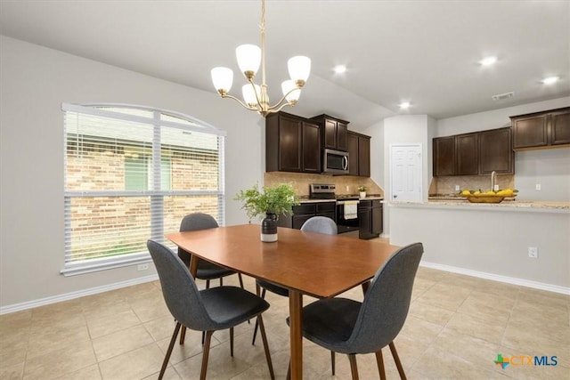 tiled dining area with a chandelier and vaulted ceiling