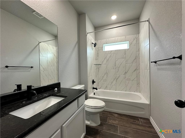 full bathroom with tiled shower / bath combo, toilet, and vanity