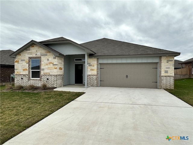 view of front of home featuring a front yard and a garage