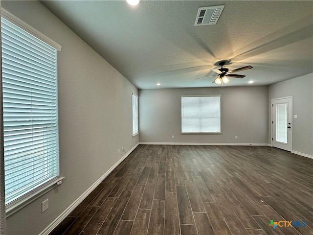 unfurnished living room featuring a textured ceiling, ceiling fan, and dark hardwood / wood-style floors