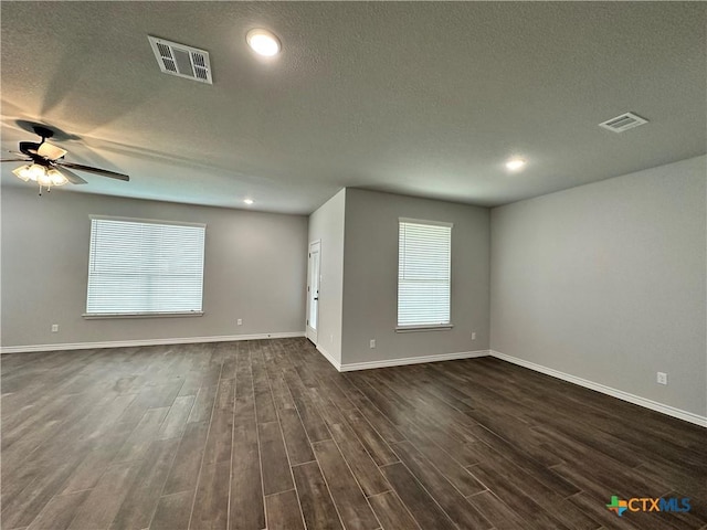 empty room with a textured ceiling, dark hardwood / wood-style floors, and ceiling fan