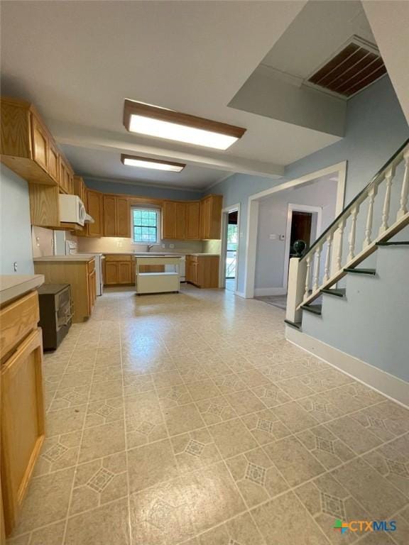 6268 Fm 2269, Buckholts, TX 76518 - kitchen with baseboards, brown cabinetry, and light countertops