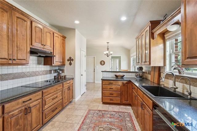120 Oak Vis, New Braunfels, TX 78132 - kitchen with a peninsula, under cabinet range hood, a sink, an inviting chandelier, and brown cabinetry
