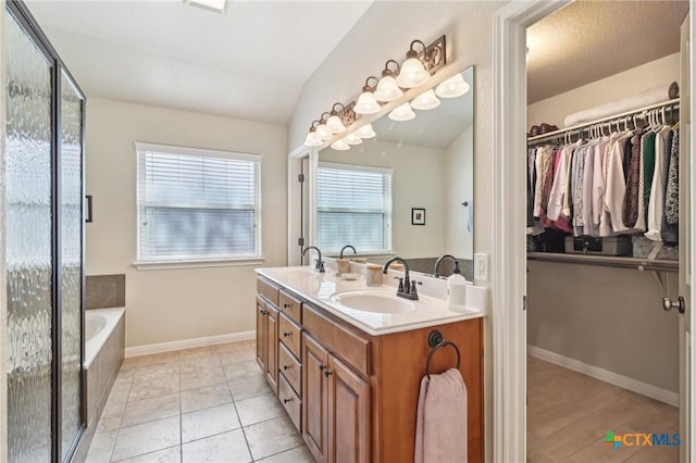 120 Oak Vis, New Braunfels, TX 78132 - full bathroom featuring a spacious closet, baseboards, a sink, double vanity, and a bath