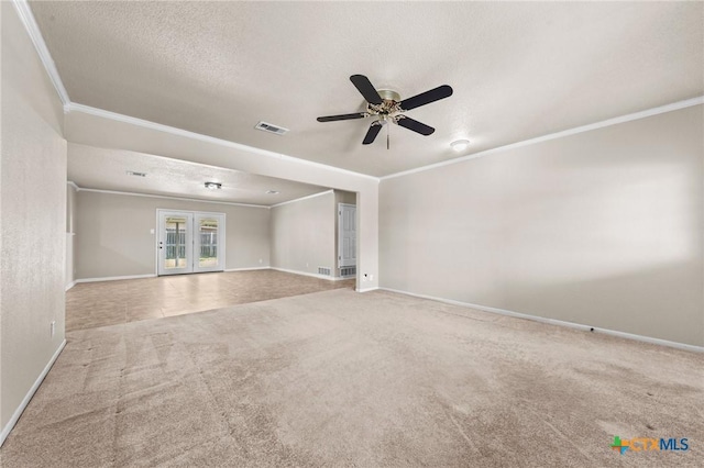 carpeted spare room with ornamental molding, baseboards, a ceiling fan, and a textured ceiling