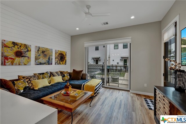 living room featuring light hardwood / wood-style flooring and ceiling fan