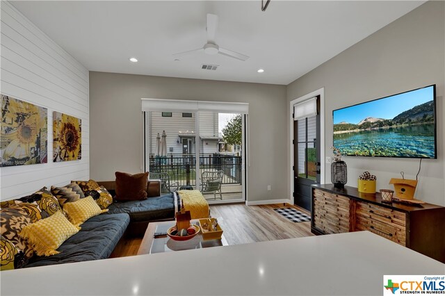 living room featuring ceiling fan and light wood-type flooring