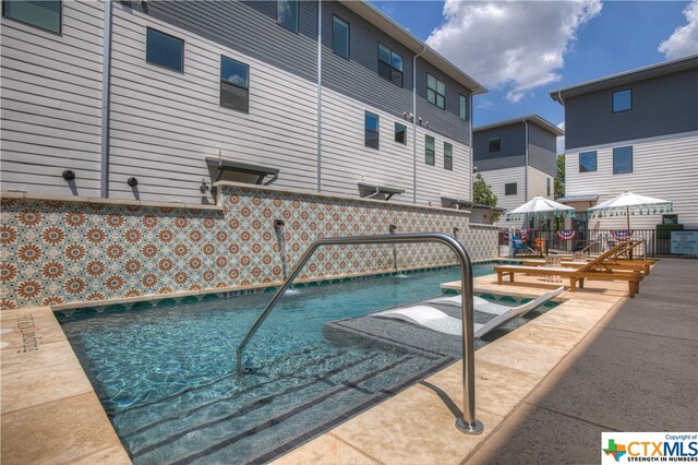 view of swimming pool featuring a wooden deck, a patio, and pool water feature