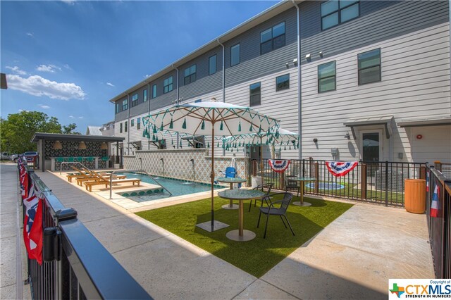 view of pool featuring a hot tub and a patio