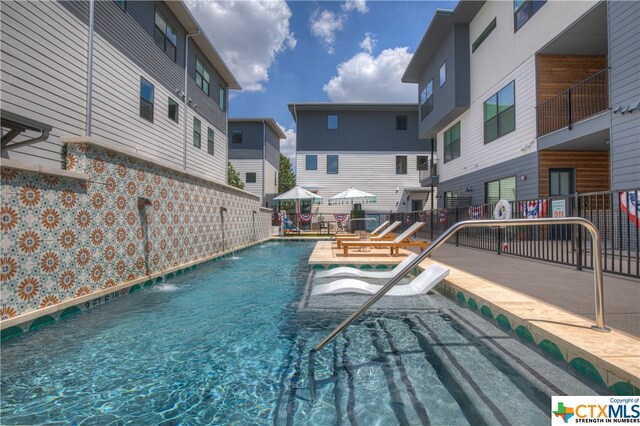 view of pool featuring a jacuzzi, a patio, and pool water feature