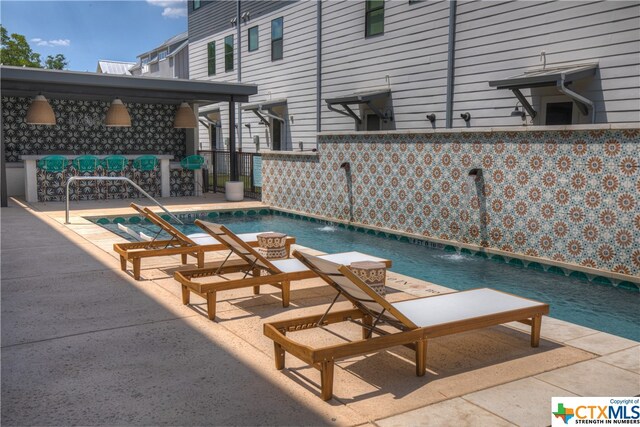 view of pool with pool water feature and a patio area