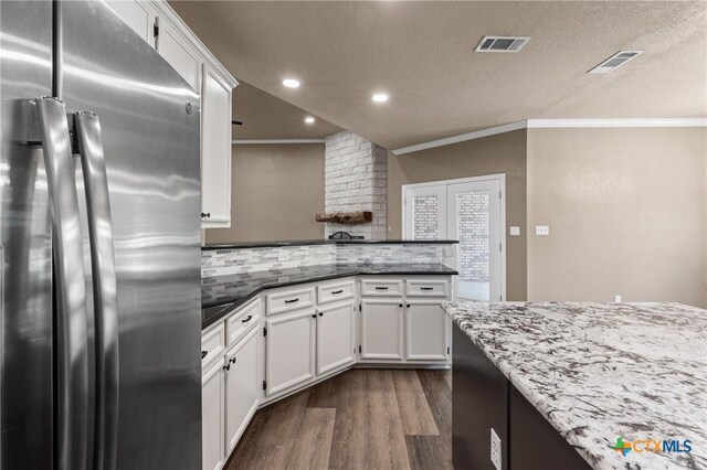 574 Rose Ln, Salado, TX 76571 - kitchen with freestanding refrigerator, dark wood finished floors, white cabinets, a peninsula, and ornamental molding