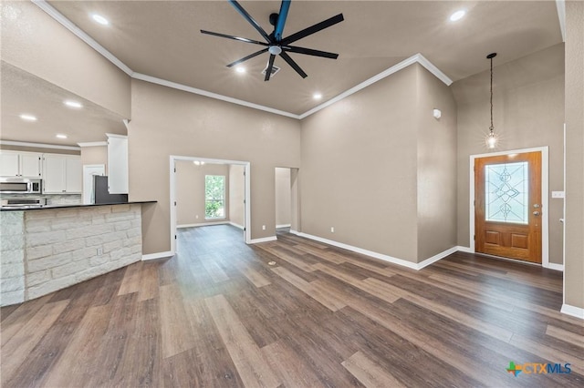 574 Rose Ln, Salado, TX 76571 - unfurnished living room featuring crown molding, a high ceiling, dark wood-style flooring, ceiling fan, and recessed lighting