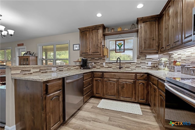 kitchen with kitchen peninsula, sink, a healthy amount of sunlight, and stainless steel appliances