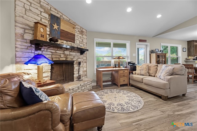 living room with lofted ceiling, light hardwood / wood-style floors, and a fireplace