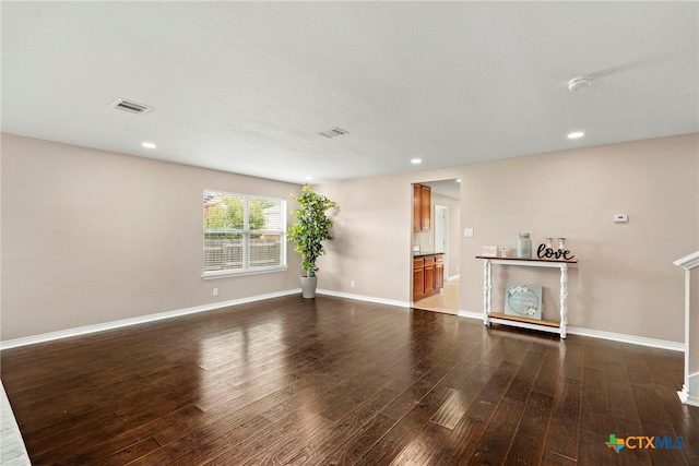 unfurnished living room with dark wood-type flooring