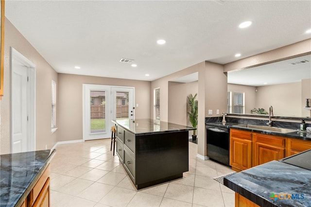 kitchen with dishwasher, dark stone counters, sink, and a center island