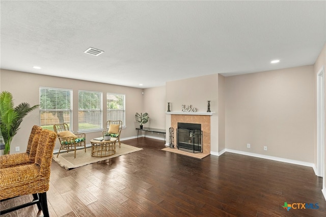 living room featuring a fireplace, dark hardwood / wood-style flooring, and a textured ceiling