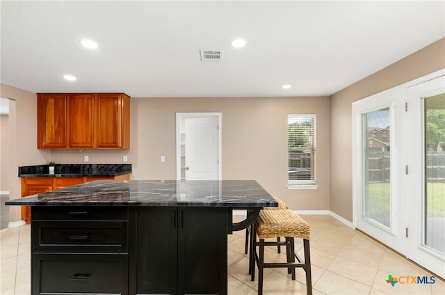 kitchen with a wealth of natural light, a kitchen bar, and a center island