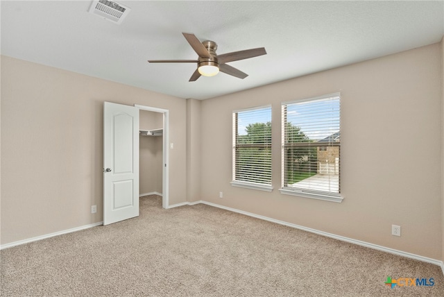 unfurnished bedroom with ceiling fan, light carpet, and a closet