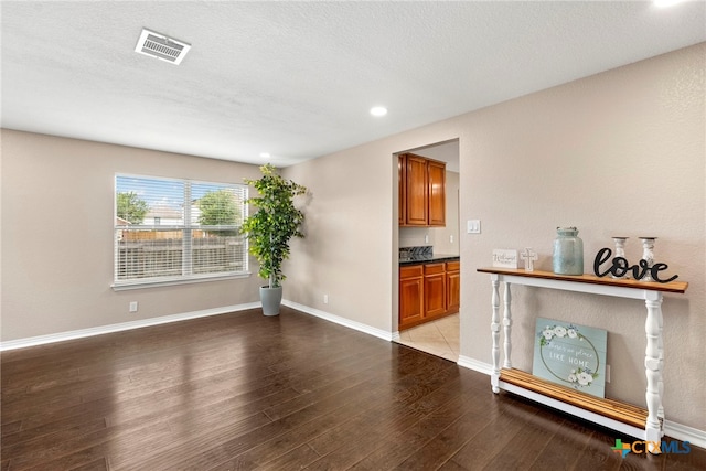 unfurnished living room featuring light hardwood / wood-style floors and a textured ceiling