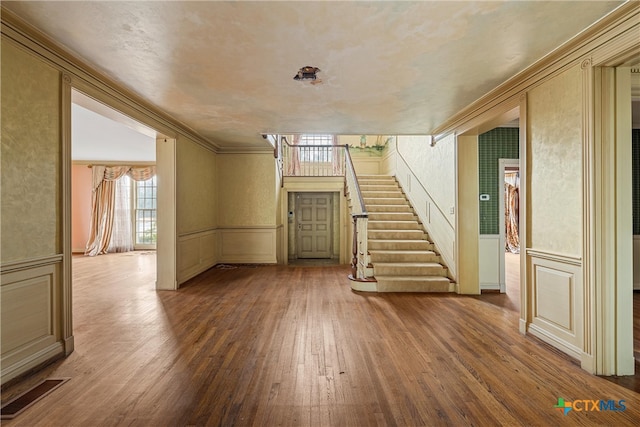 interior space with hardwood / wood-style floors and crown molding