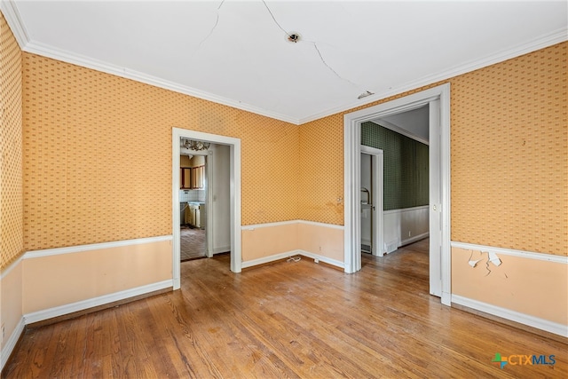 spare room featuring hardwood / wood-style flooring and crown molding