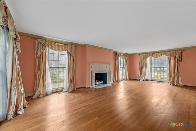 unfurnished living room with crown molding, light hardwood / wood-style floors, and plenty of natural light