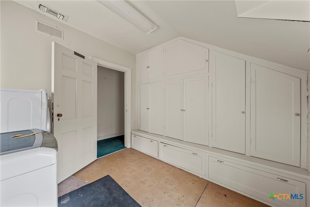 laundry area with washing machine and clothes dryer and cabinets