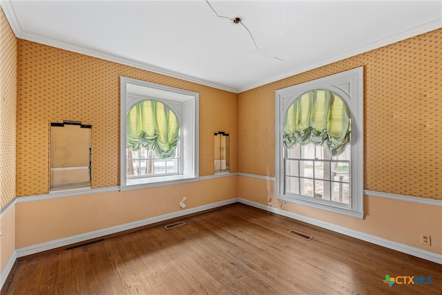 spare room with wood-type flooring and crown molding