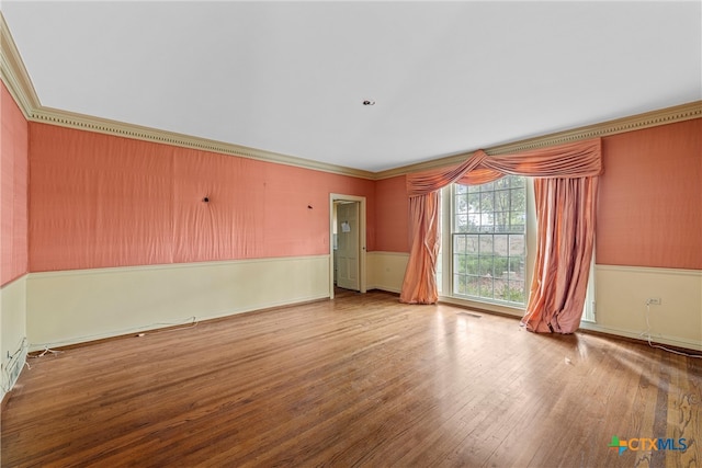 unfurnished room featuring wood-type flooring and ornamental molding