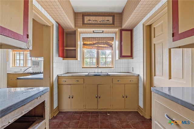 kitchen with tile walls, sink, dark tile patterned flooring, and tasteful backsplash