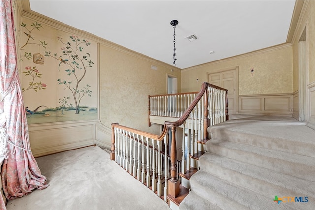 staircase featuring crown molding and carpet floors