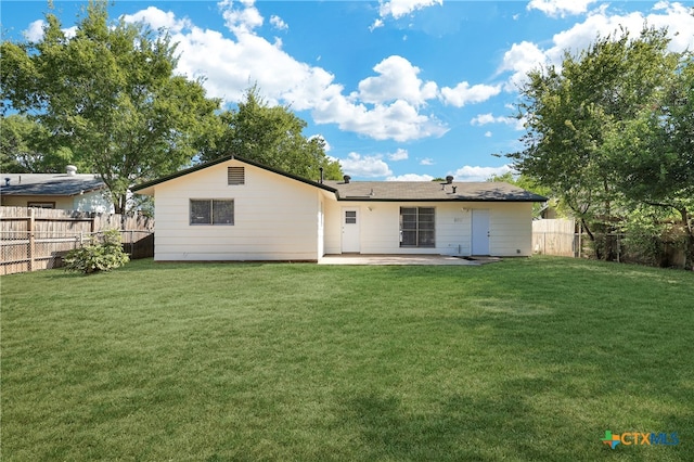 back of house with a lawn and a patio area