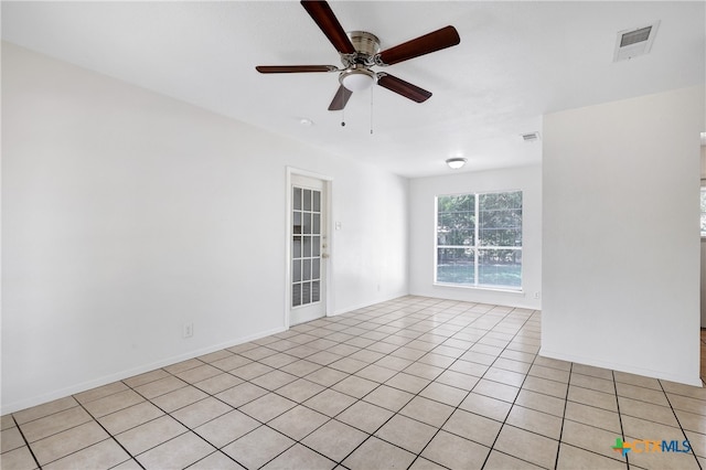 tiled spare room featuring ceiling fan