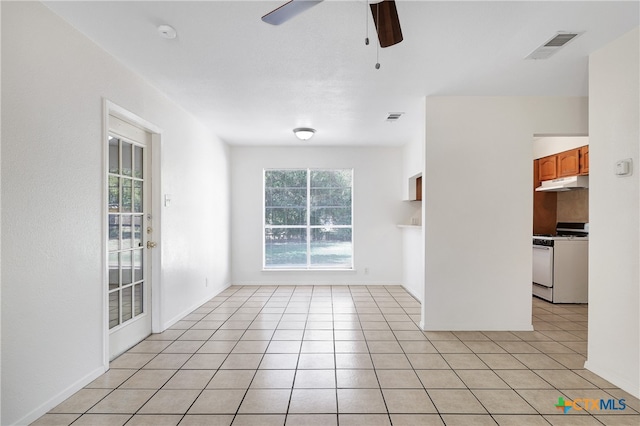 tiled spare room featuring a healthy amount of sunlight and ceiling fan