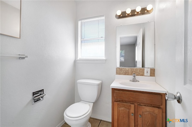 bathroom with toilet, vanity, and tile patterned floors