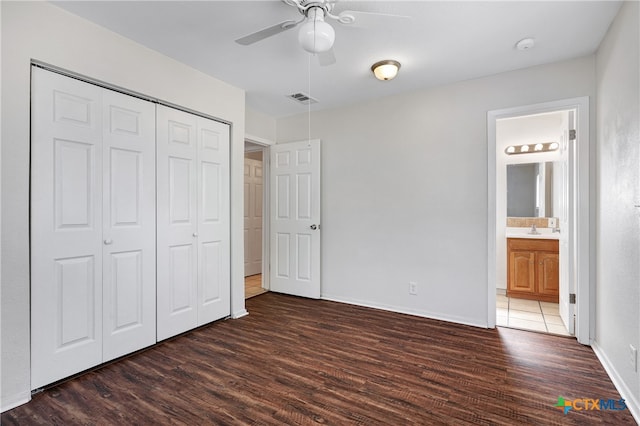 unfurnished bedroom featuring a closet, dark hardwood / wood-style floors, ceiling fan, and connected bathroom