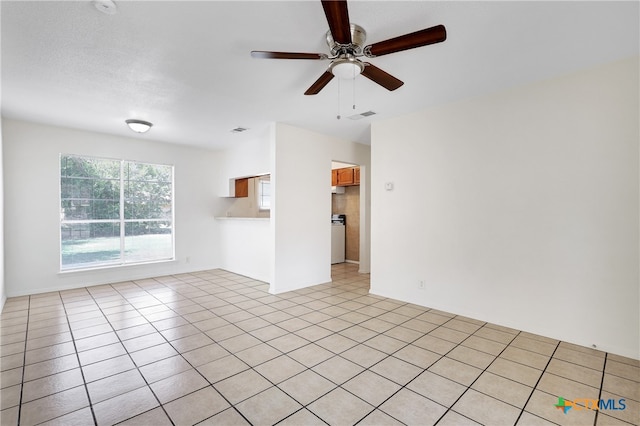 tiled spare room with ceiling fan