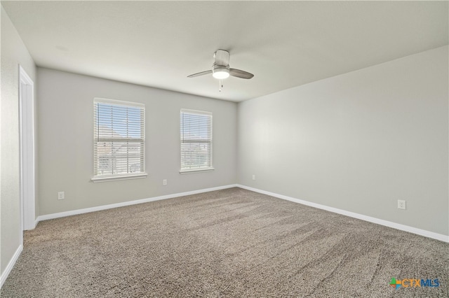 carpeted spare room featuring ceiling fan